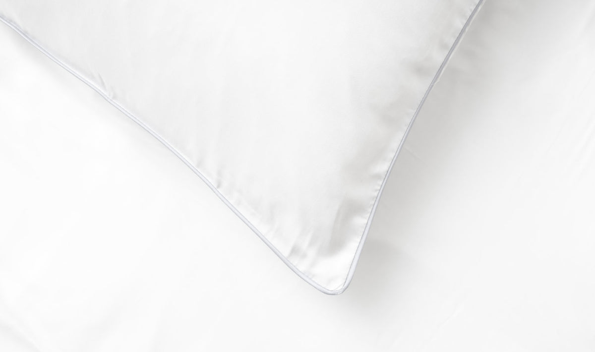 Close-up of white Sloth London bamboo bedding with coloured piping